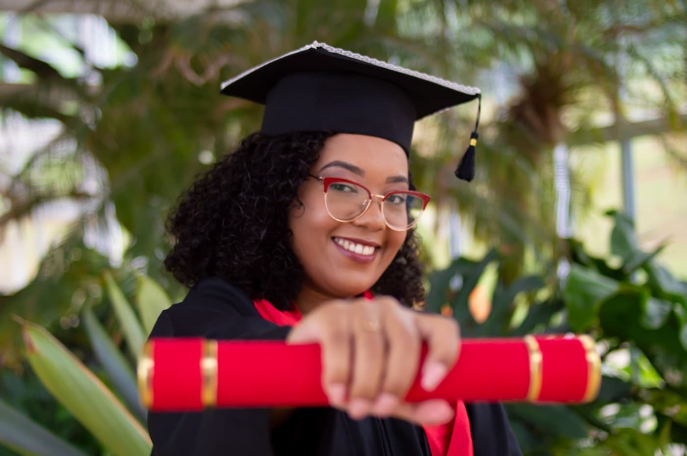A smiling graduate holding her diploma