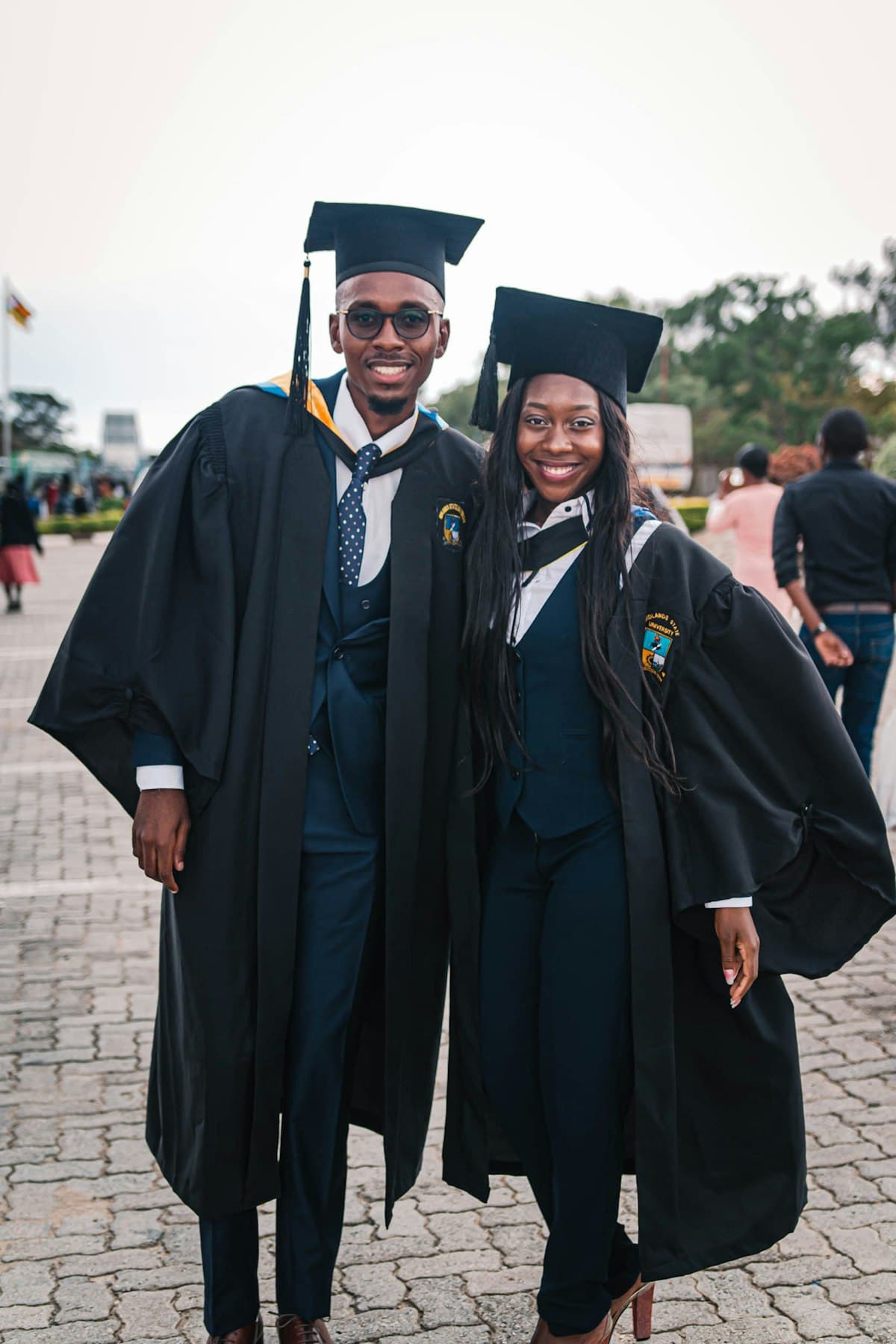 A graduate in a black academic gown on a university campus