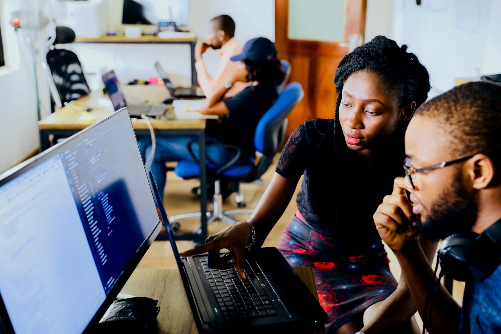 Two students reviewing code together on laptops